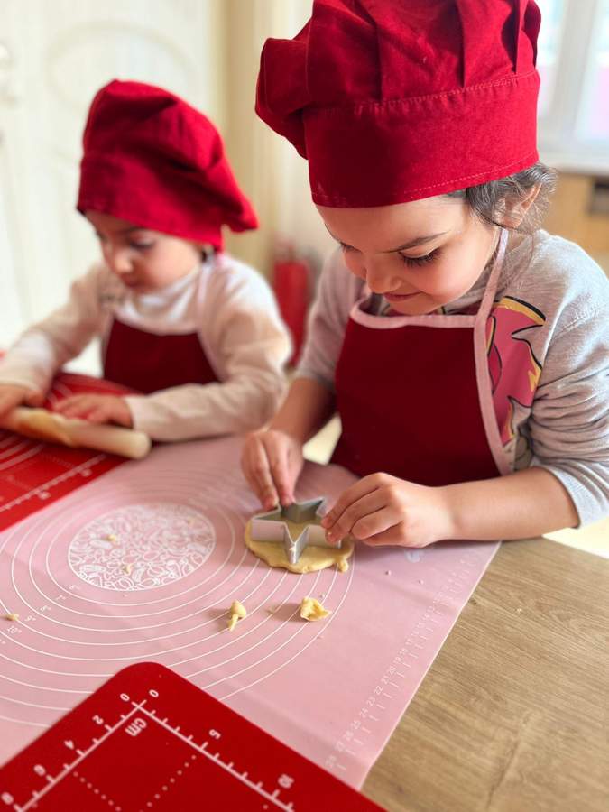 Mutfak atölyesinde kurabiye kesen çocuklar
